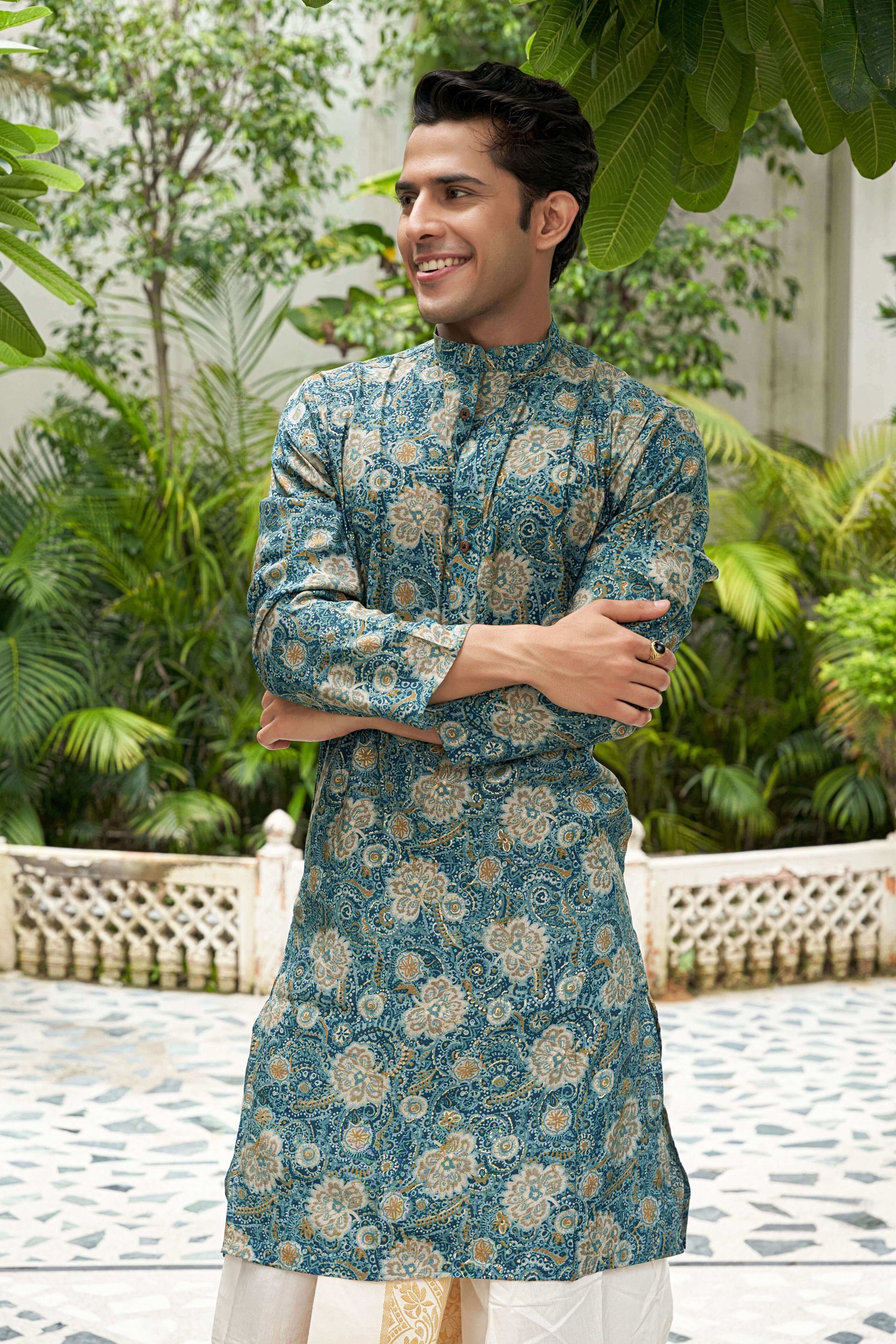 An Indian man wearing an ocean blue foil print long kurta, standing confidently with a neutral background. 