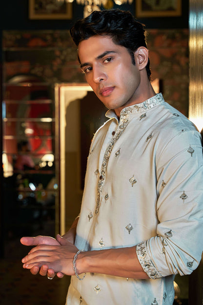 green embroidery work long kurta worn by an indian man. 