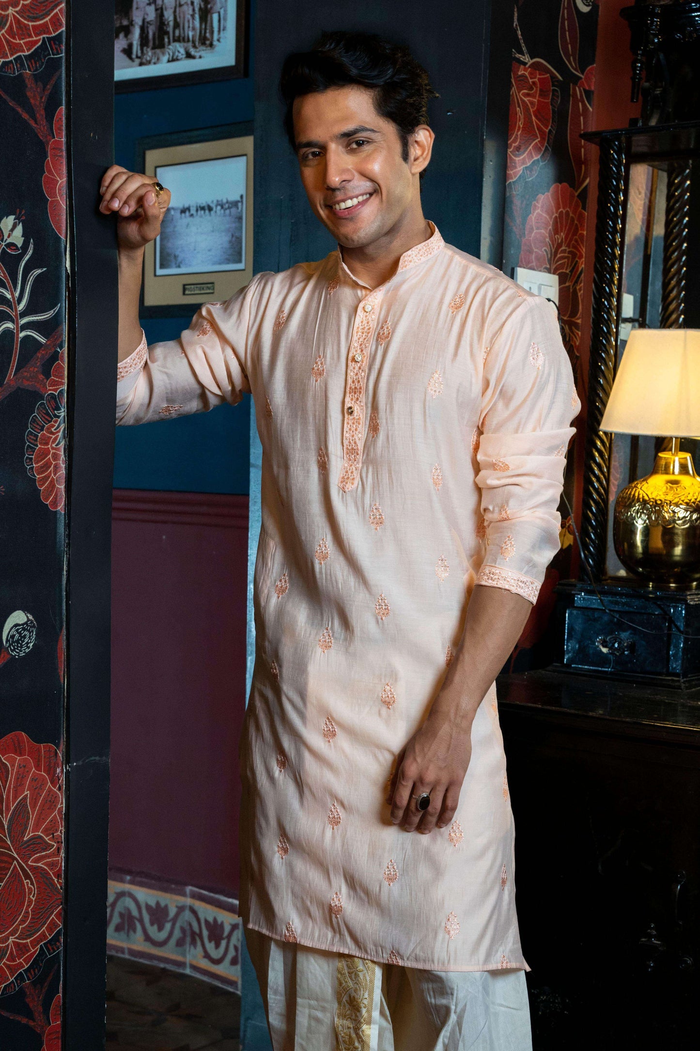 Pink embroidery work long kurta worn by an Indian man. 