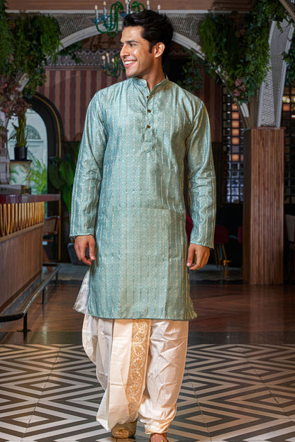 zari work long kurta worn by an indian man. posing with a beautiful background. 