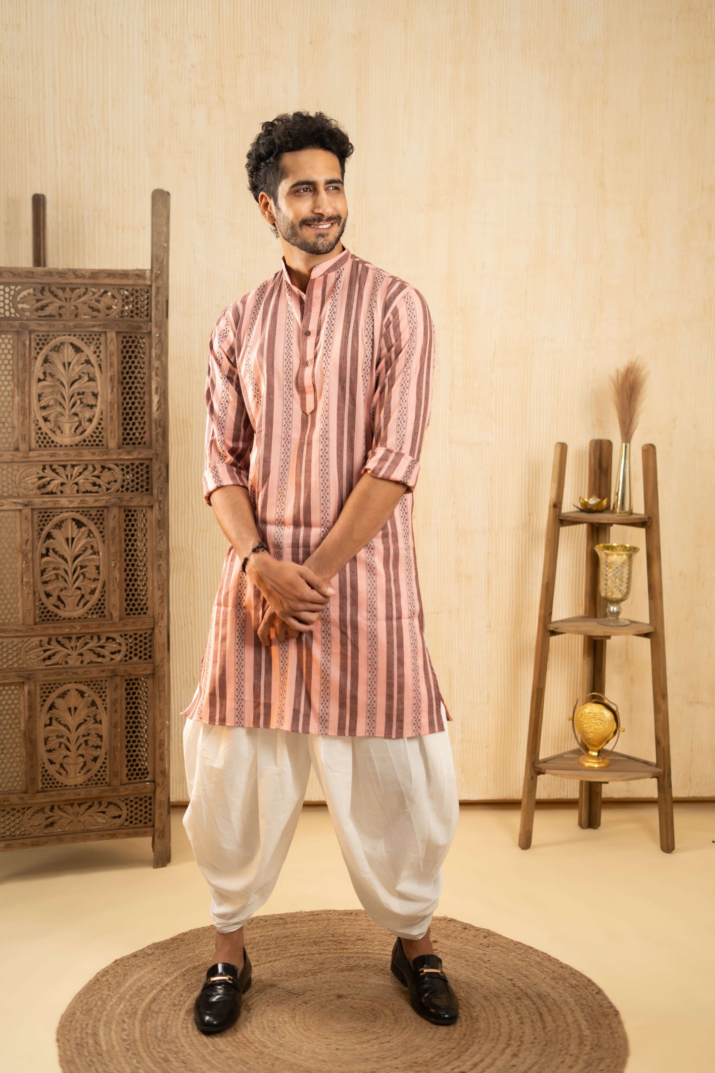 A man wearing a traditional Indian kurta and dhoti, showcasing vibrant colors and intricate patterns.