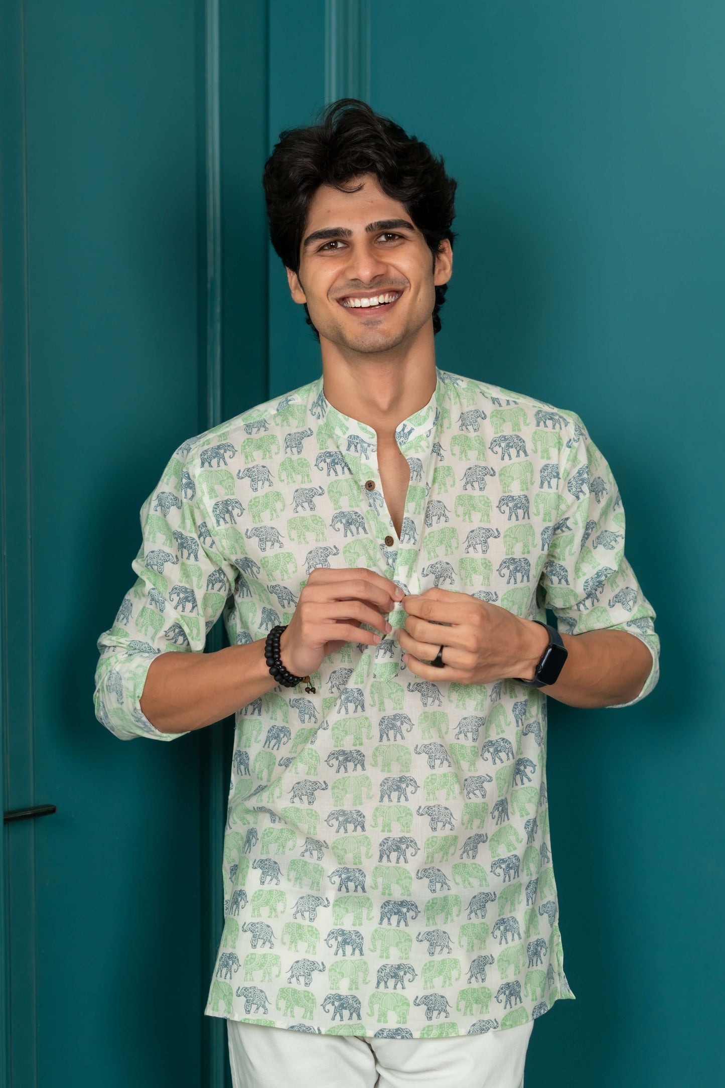 white short kurta for men is worn by an Indian model. featuring black jewelry.  