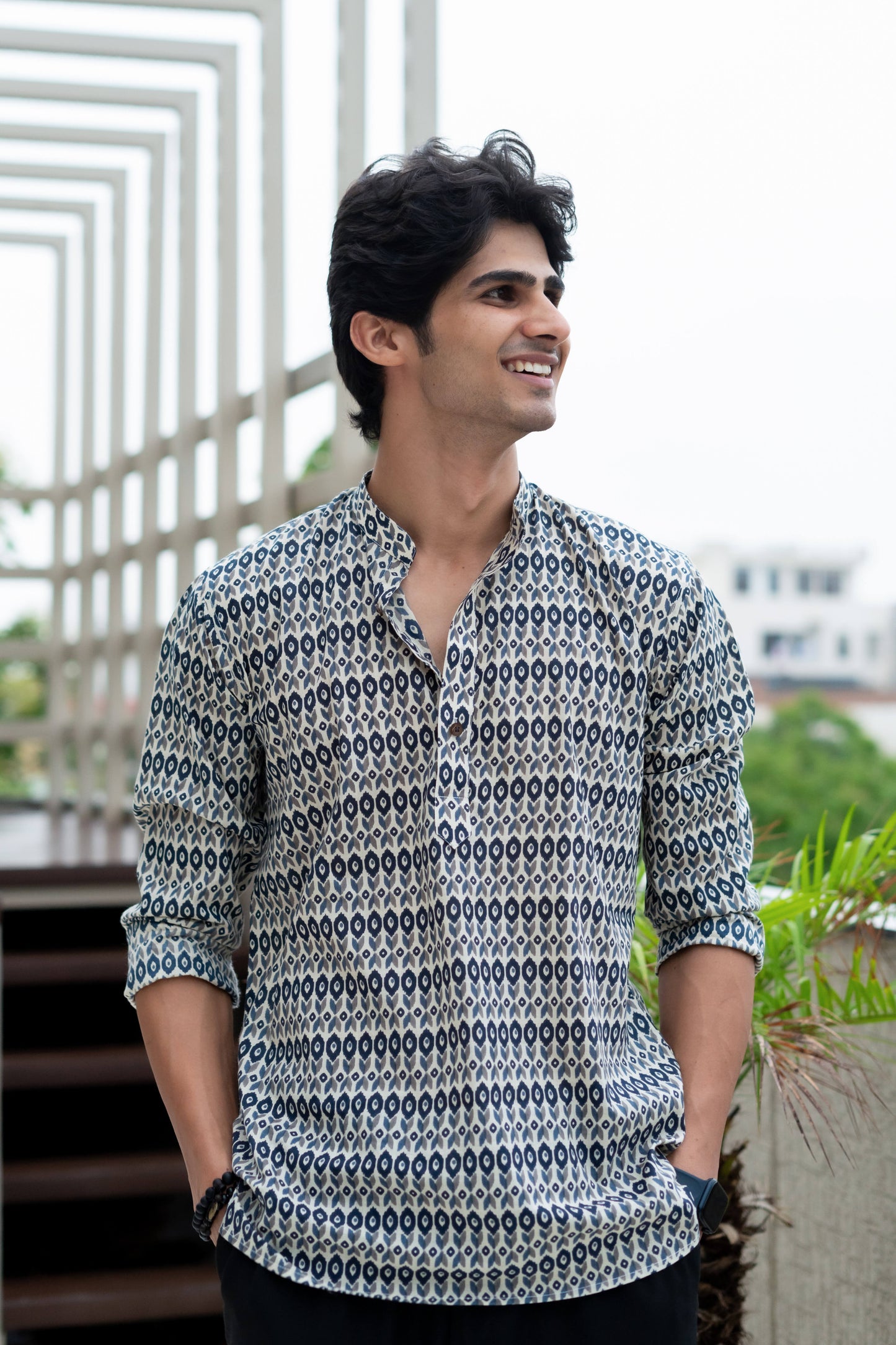 Indian man wearing a printed white short kurta with a black color jeans.